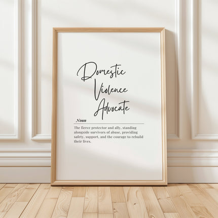 Elegant black and white typography print featuring 'Domestic Violence Advocate' in bold script with supportive definition in serif font against clean white background, framed in natural wood.