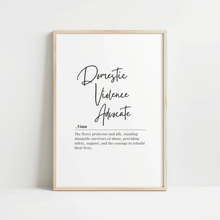 Elegant black and white typography print featuring 'Domestic Violence Advocate' in bold script with supportive definition in serif font against clean white background, framed in natural wood.