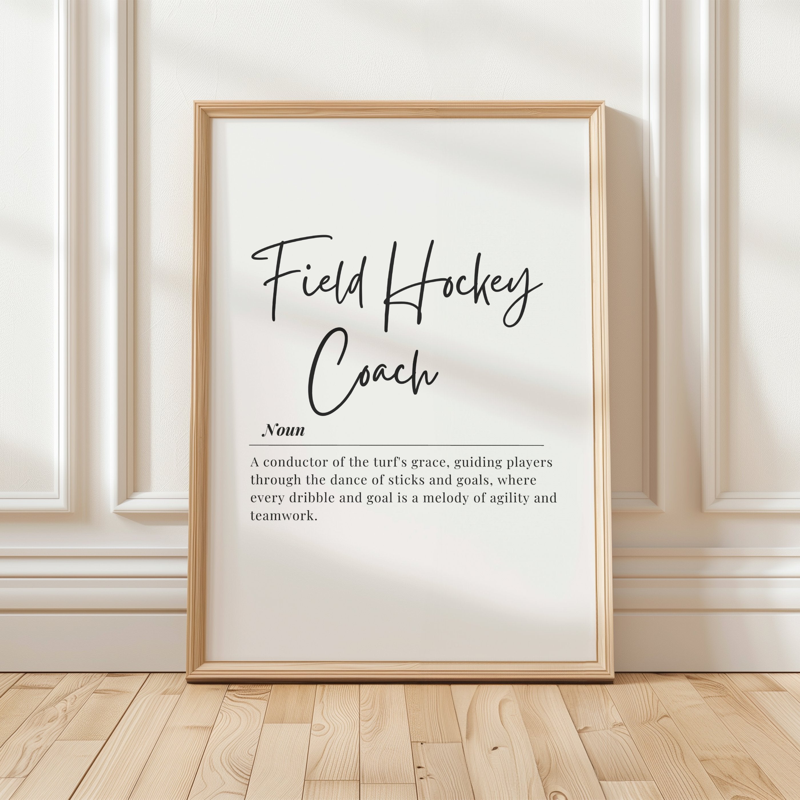Elegant field hockey coach definition typography print featuring black script and serif fonts on white background, blending motivational quote with minimalist design for professional sports environments.