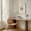 Delicate white magnolia branch with lush green leaves on crisp white background, creating a serene botanical illustration with vintage elegance perfect for traditional or rustic spaces.