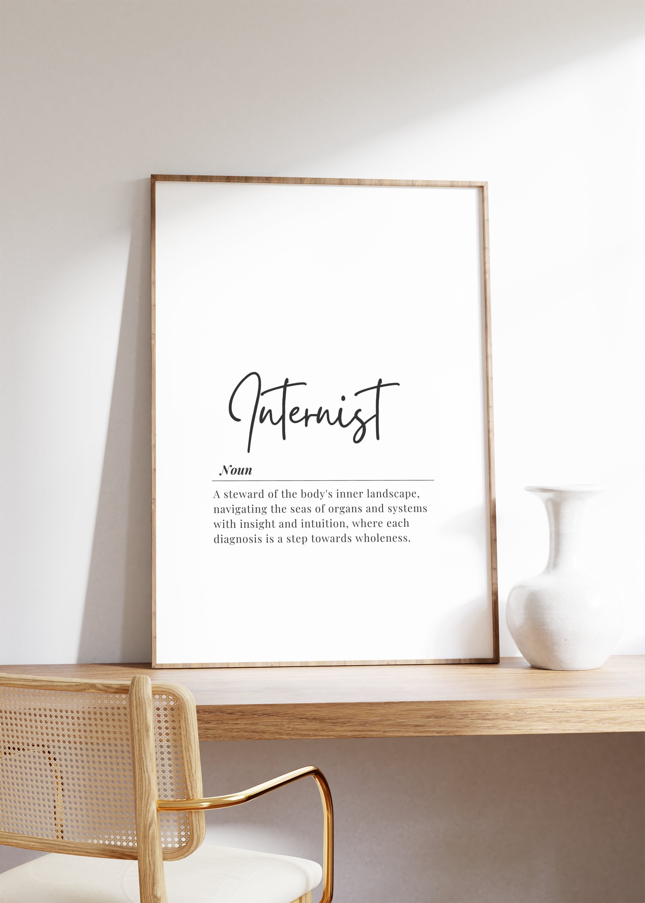 Minimalist typography print featuring 'Internist' in bold sans-serif font with an elegant definition beneath on white background with wood frame, creating a sophisticated professional aesthetic.