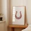 Minimalist copper horseshoe against white background in rustic frame, conveying warmth and protection through simple, elegant design perfect for farmhouse or Scandinavian decor.
