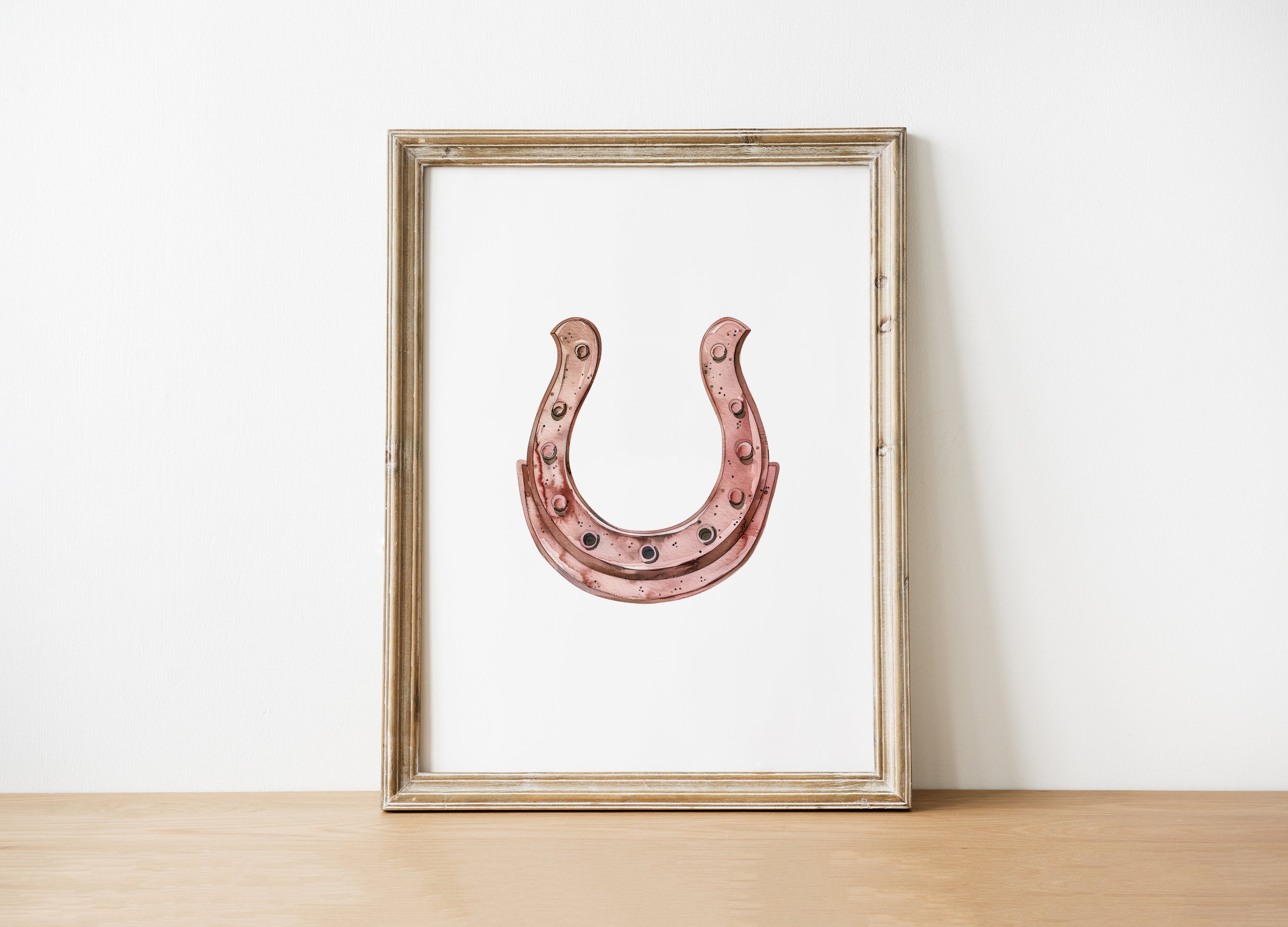 Minimalist copper horseshoe against white background in rustic frame, conveying warmth and protection through simple, elegant design perfect for farmhouse or Scandinavian decor.