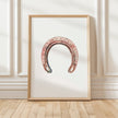 Minimalist vintage horseshoe print in warm copper tones against crisp white background, featuring rustic texturing and simple composition perfect for farmhouse and Scandinavian decor