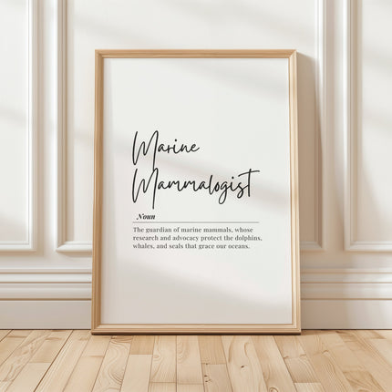 Minimalist typography print featuring 'Marine Mammalogist' in elegant black script with serif definition text against white background, framed in oak, celebrating ocean conservation professionals.