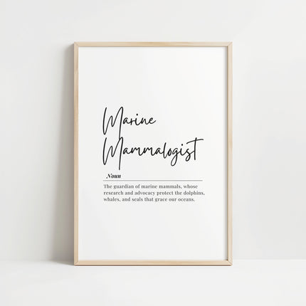 Minimalist typography print featuring 'Marine Mammalogist' in elegant black script with serif definition text against white background, framed in oak, celebrating ocean conservation professionals.
