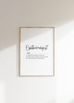 Minimalist ophthalmologist definition print with elegant typography, featuring black script against white background in a natural wood frame, conveying professional clarity and sophisticated aesthetic for medical spaces.