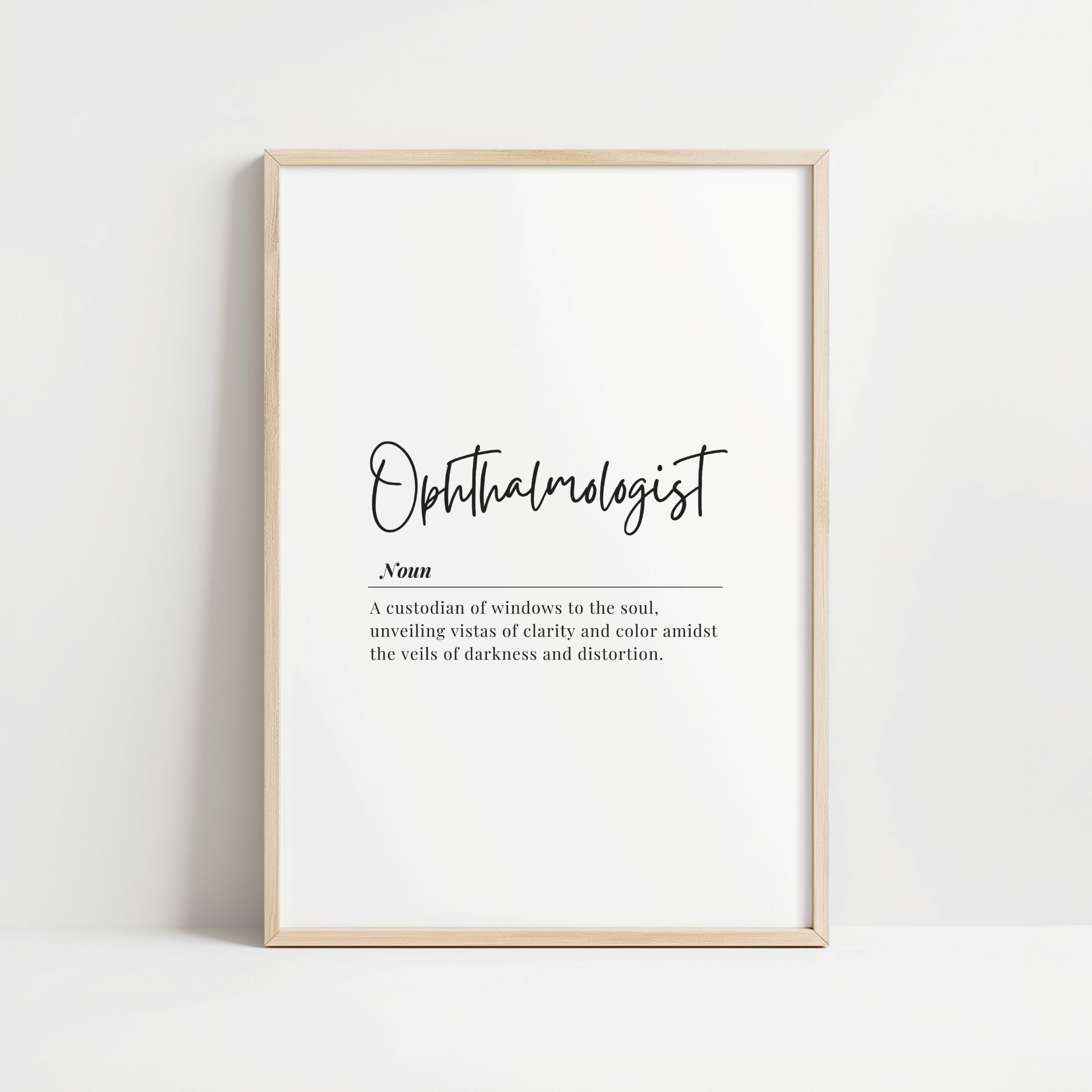 Minimalist ophthalmologist definition print with elegant typography, featuring black script against white background in a natural wood frame, conveying professional clarity and sophisticated aesthetic for medical spaces.