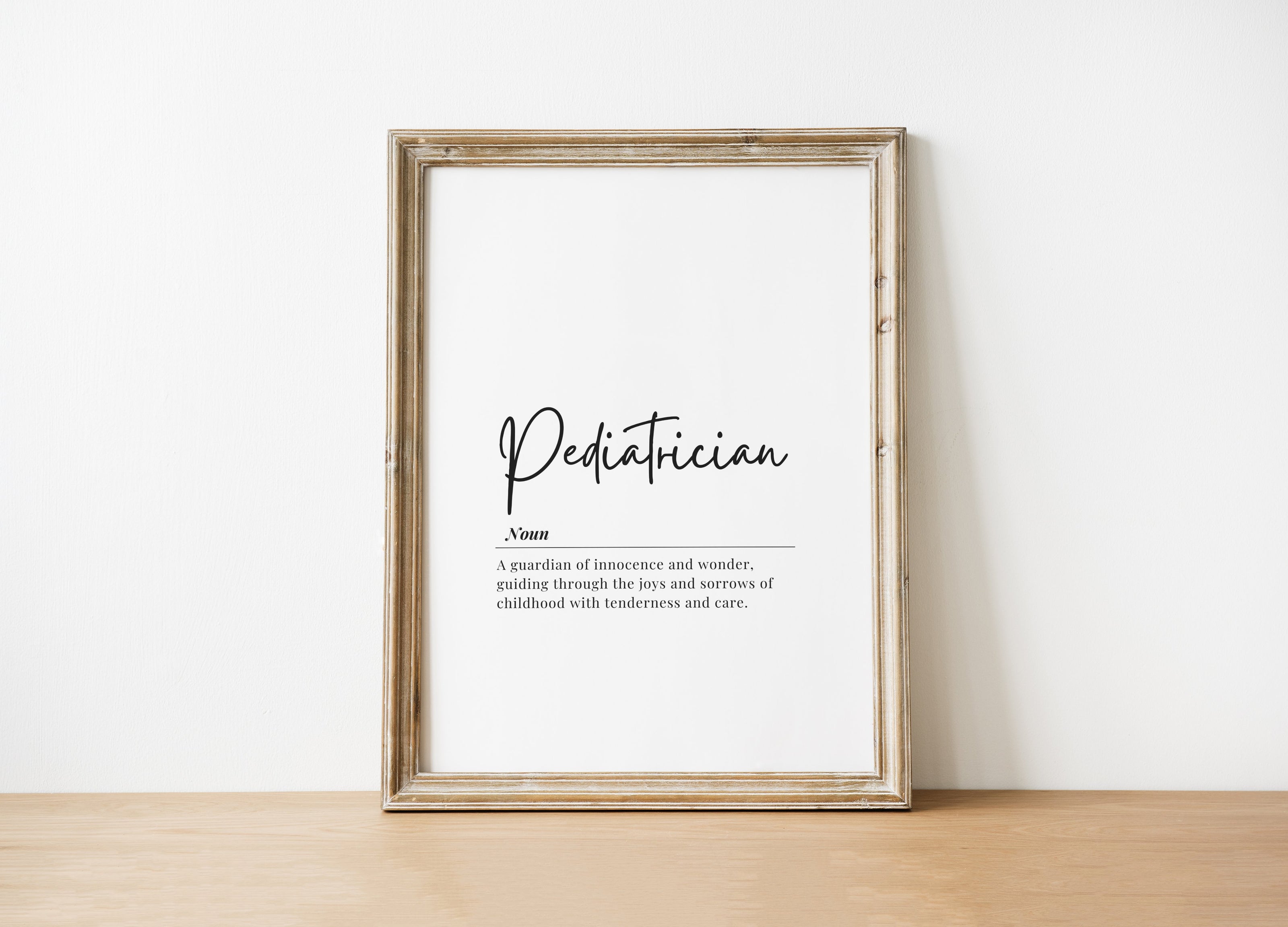 Minimalist black typography on white background displaying 'Pediatrician' definition with elegant script, framed in clean wood, perfect for pediatric offices and waiting rooms.