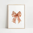 Vintage plaid bow in warm terracotta and cream tones against a white background, featuring intricate pattern detail with rustic charm perfect for farmhouse-inspired spaces.
