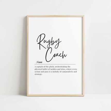 Modern typography print with 'Rugby Coach' in flowing script against white background, featuring inspirational definition about orchestrating the physical ballet of rugby, framed in natural wood.