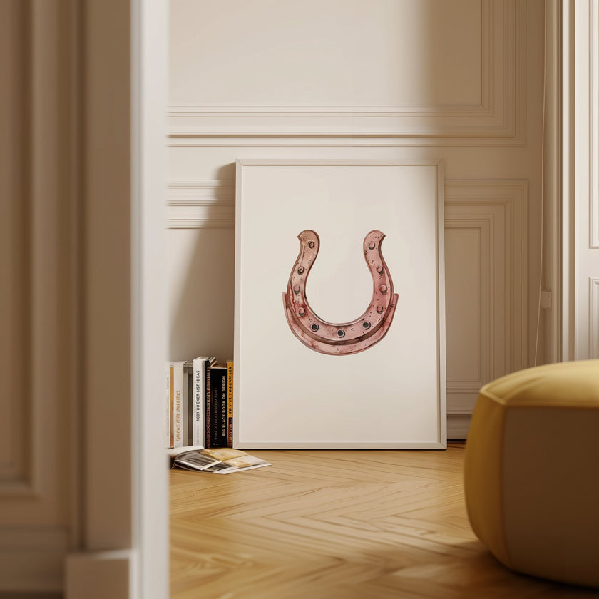 Elegant minimalist horseshoe in muted rose gold against white background, featuring detailed rivets and rustic finish, framed in natural wood for good luck charm in modern farmhouse decor.