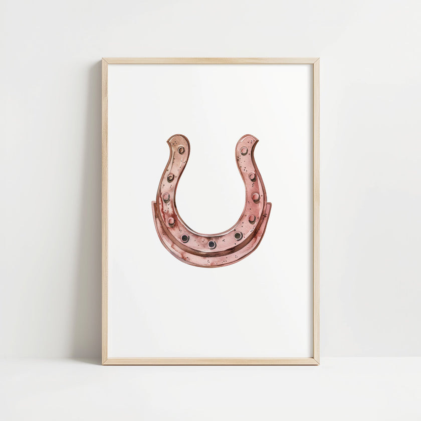 Elegant minimalist horseshoe in muted rose gold against white background, featuring detailed rivets and rustic finish, framed in natural wood for good luck charm in modern farmhouse decor.