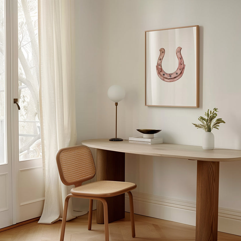 Elegant minimalist horseshoe in muted rose gold against white background, featuring detailed rivets and rustic finish, framed in natural wood for good luck charm in modern farmhouse decor.