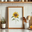 Watercolor sunflower in vibrant golden-yellow with delicate green leaves against a clean white background, displayed in a rustic wooden frame creating a minimalist, calming aesthetic.