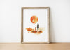 Minimalist watercolor print featuring silhouettes of a person and dog against a vivid burnt orange sunset in a desert landscape, conveying serenity and adventure in warm earthy tones.