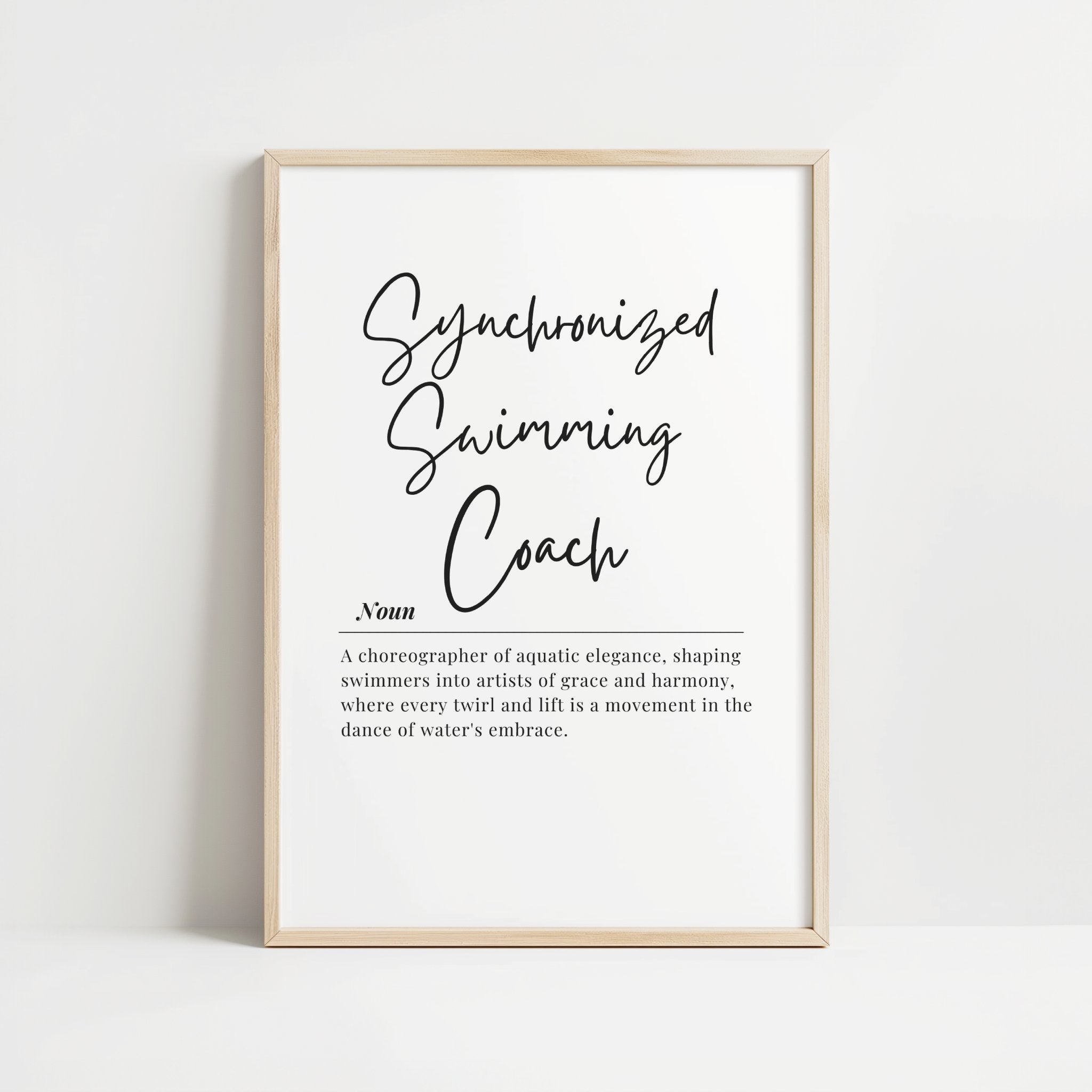 Minimalist typographic print with 'Synchronized Swimming Coach' in elegant charcoal gray script against white background, framed in clean wood, ideal for coaching offices or aquatic facilities.