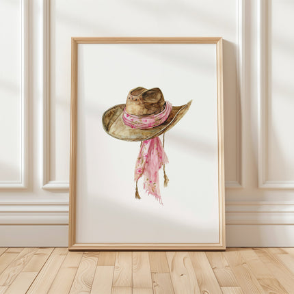 Delicate watercolor cowgirl hat with soft pink floral scarf against white background, featuring gentle brushstrokes and earthy tones perfect for rustic farmhouse decor.