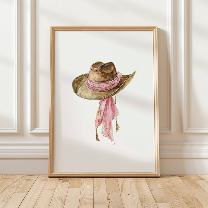 Delicate watercolor cowgirl hat with soft pink floral scarf against white background, featuring gentle brushstrokes and earthy tones perfect for rustic farmhouse decor.