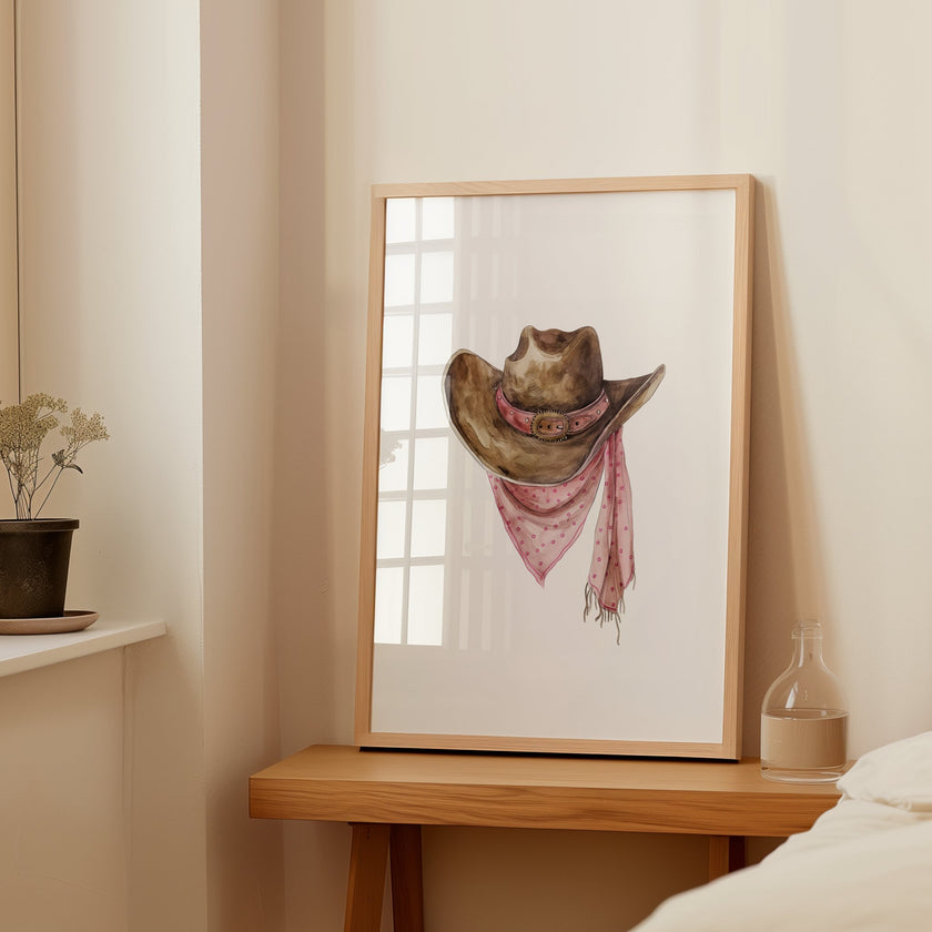 Rustic watercolor cowboy hat with pink polka dot bandana against white background, featuring detailed brushstrokes and soft muted colors perfect for farmhouse and western-themed spaces.