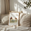 Serene watercolor scene of woman and horse in meadow, depicted in warm chestnut brown, sage green and gold tones on minimalist white background with rustic wooden frame elements