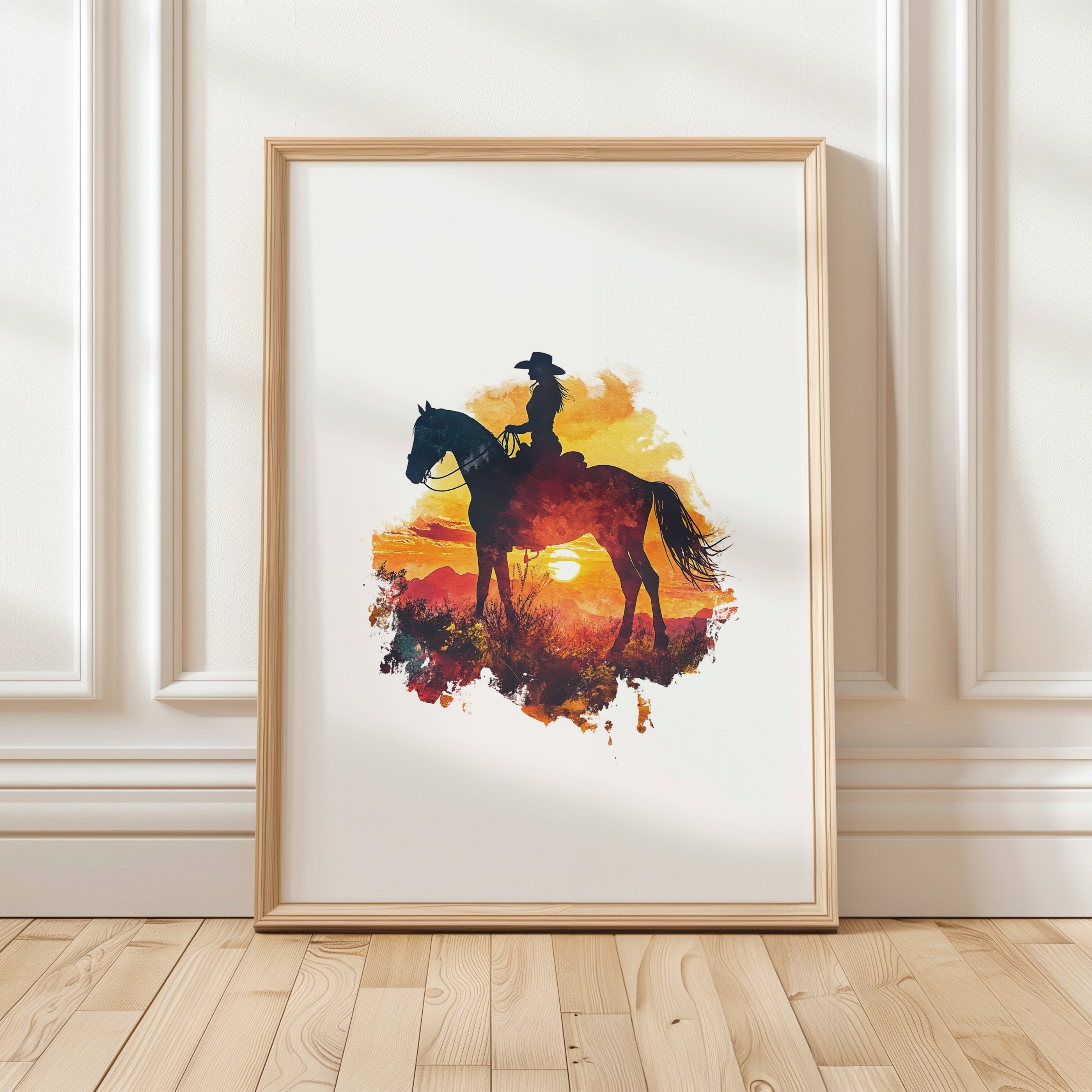 Dramatic silhouette of cowboy on horseback against vibrant orange, red and yellow sunset, featuring textured watercolor splashes creating a nostalgic, adventurous western landscape perfect for rustic decor.