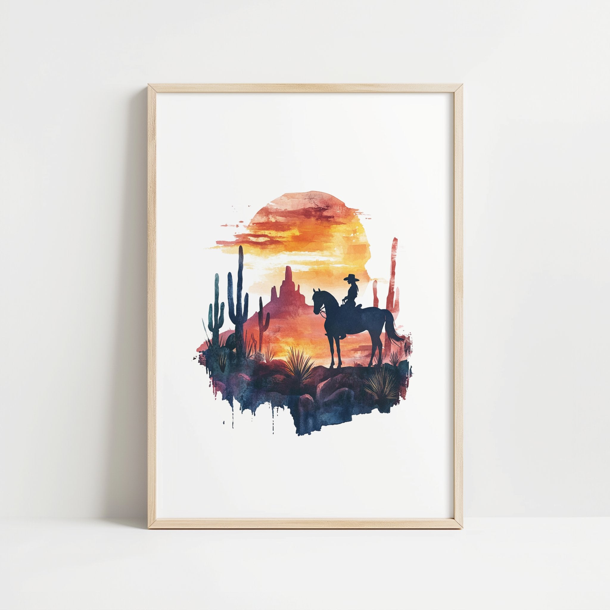 Silhouetted cowboy on horseback against vibrant orange and red sunset with navy blue mountains, cacti and desert formations creating a powerful rustic southwestern aesthetic.