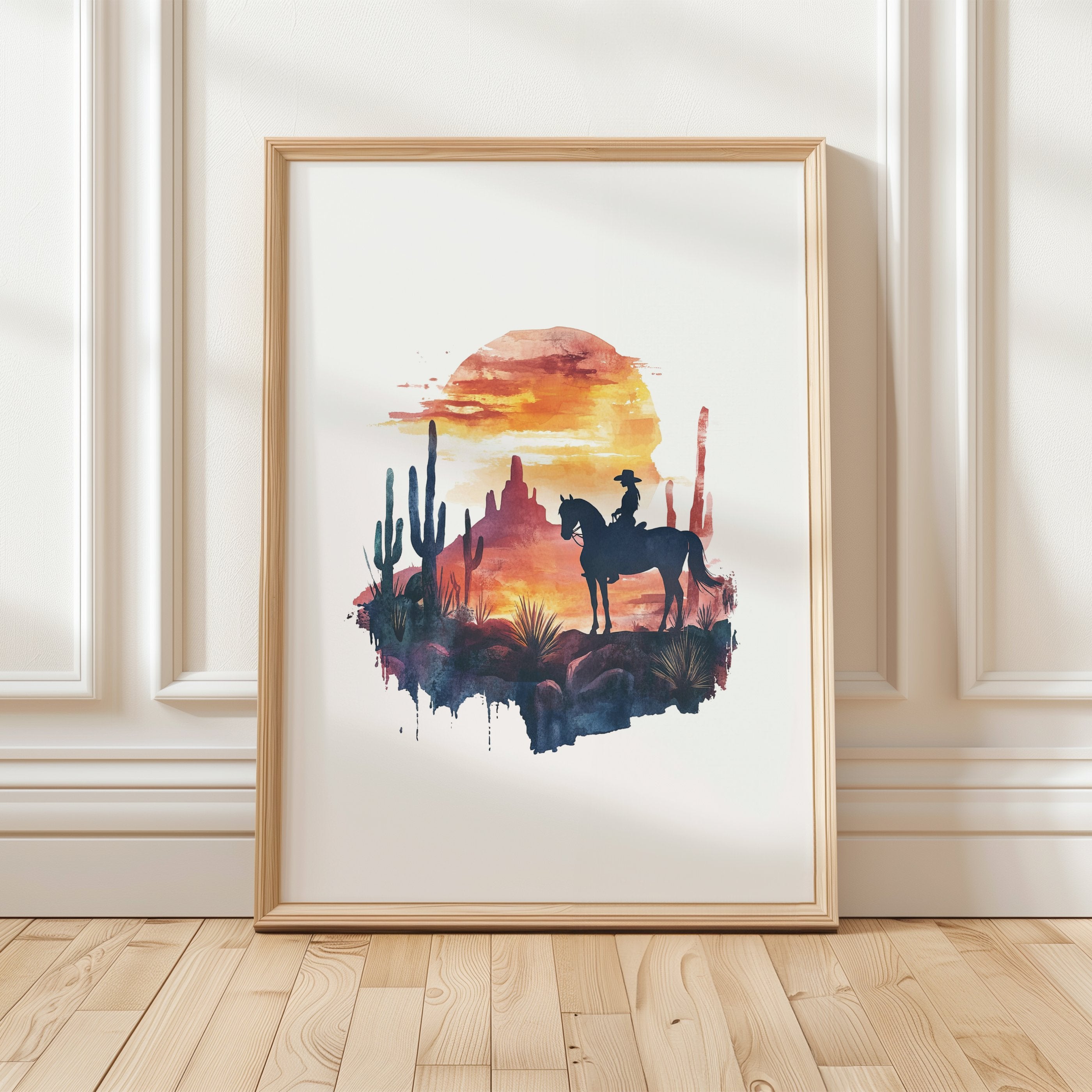 Silhouetted cowboy on horseback against vibrant orange and red sunset with navy blue mountains, cacti and desert formations creating a powerful rustic southwestern aesthetic.