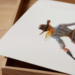 Watercolor cowgirl drawing a revolver in teal, sand, and cinnamon tones against white background, conveying motion and independence with flowing skirt and hat, perfect for modern farmhouse decor.