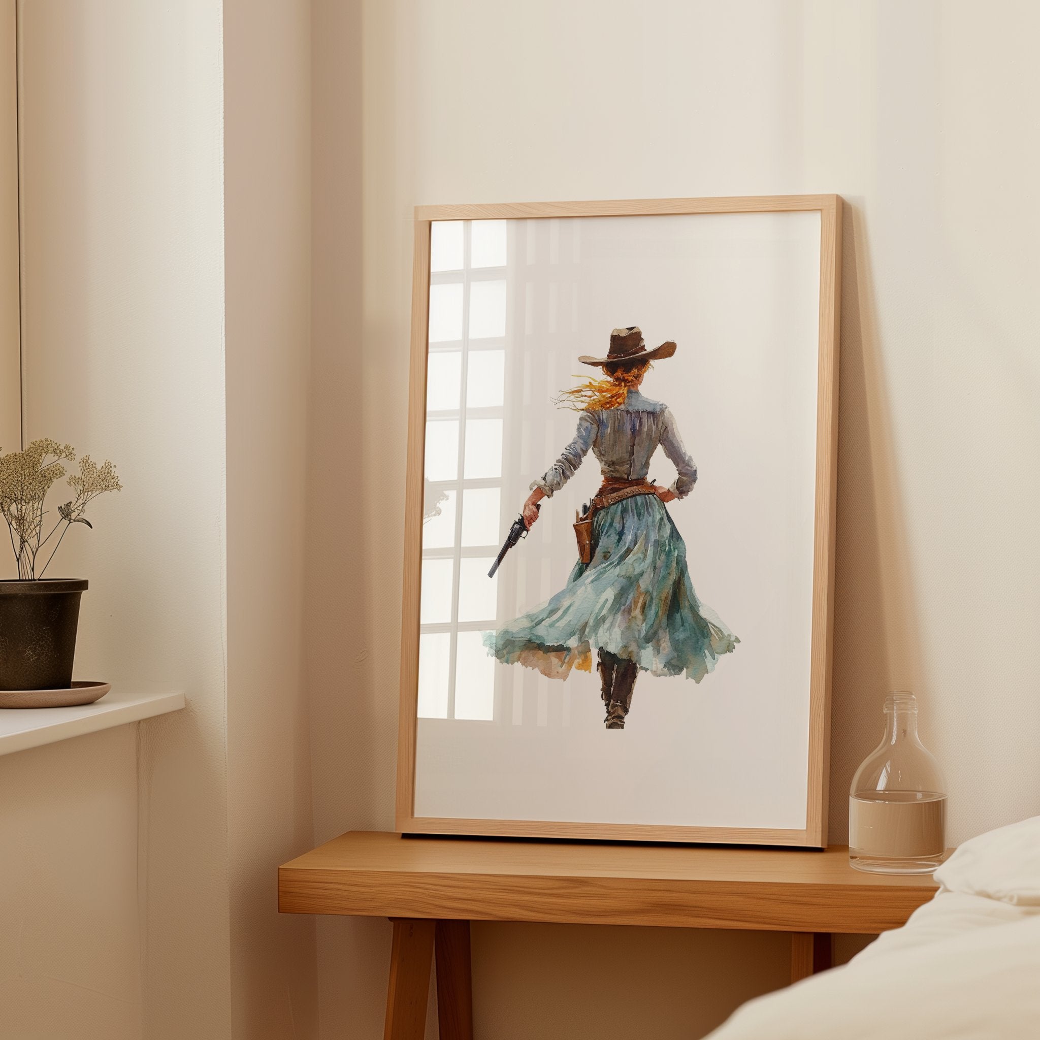 Watercolor cowgirl drawing a revolver in teal, sand, and cinnamon tones against white background, conveying motion and independence with flowing skirt and hat, perfect for modern farmhouse decor.