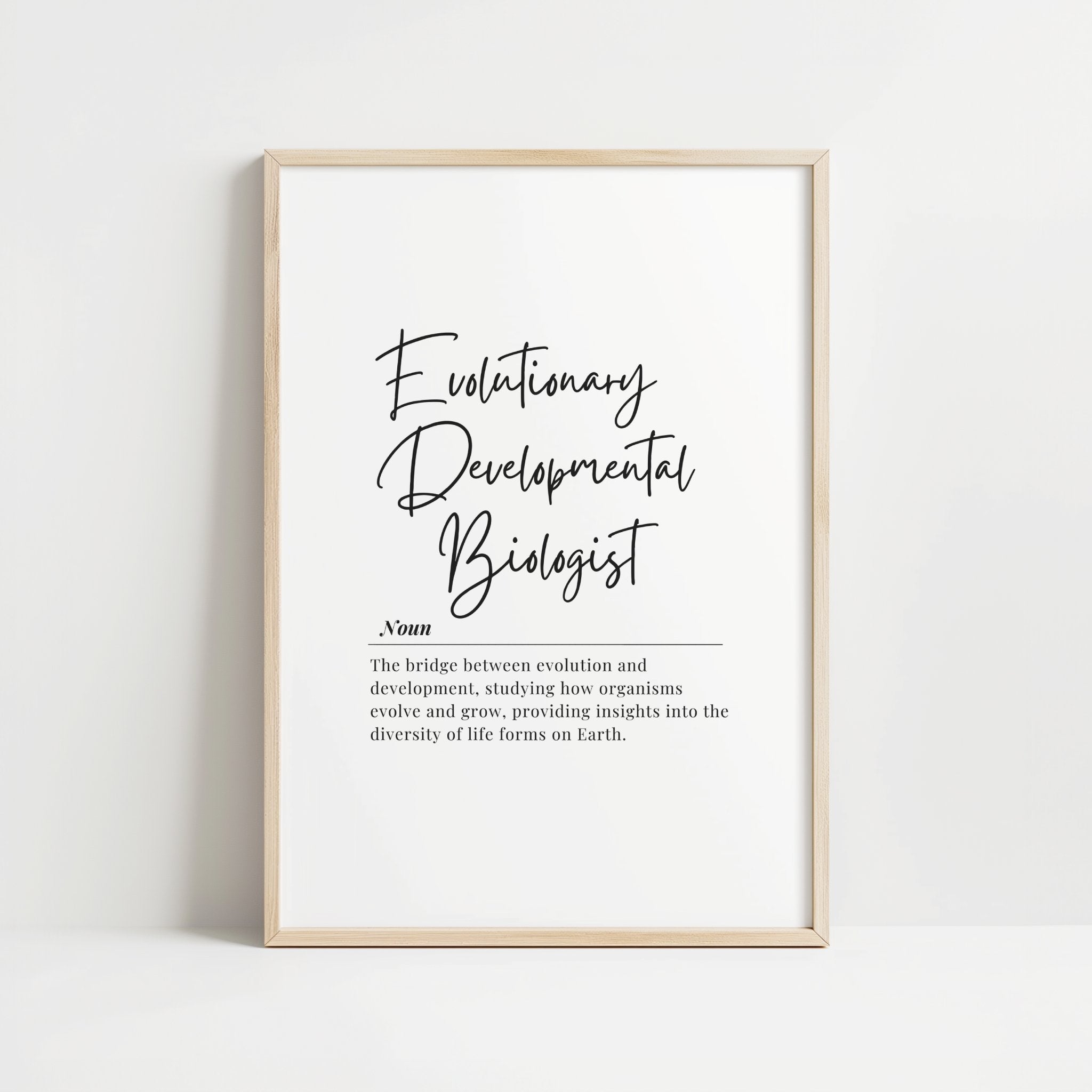 Elegant black typography print featuring 'Evolutionary Developmental Biologist' in modern script against white background with definition text in clean serif font, framed in natural wood