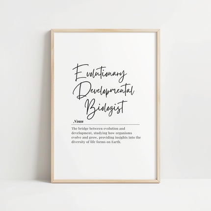 Elegant black typography print featuring 'Evolutionary Developmental Biologist' in modern script against white background with definition text in clean serif font, framed in natural wood
